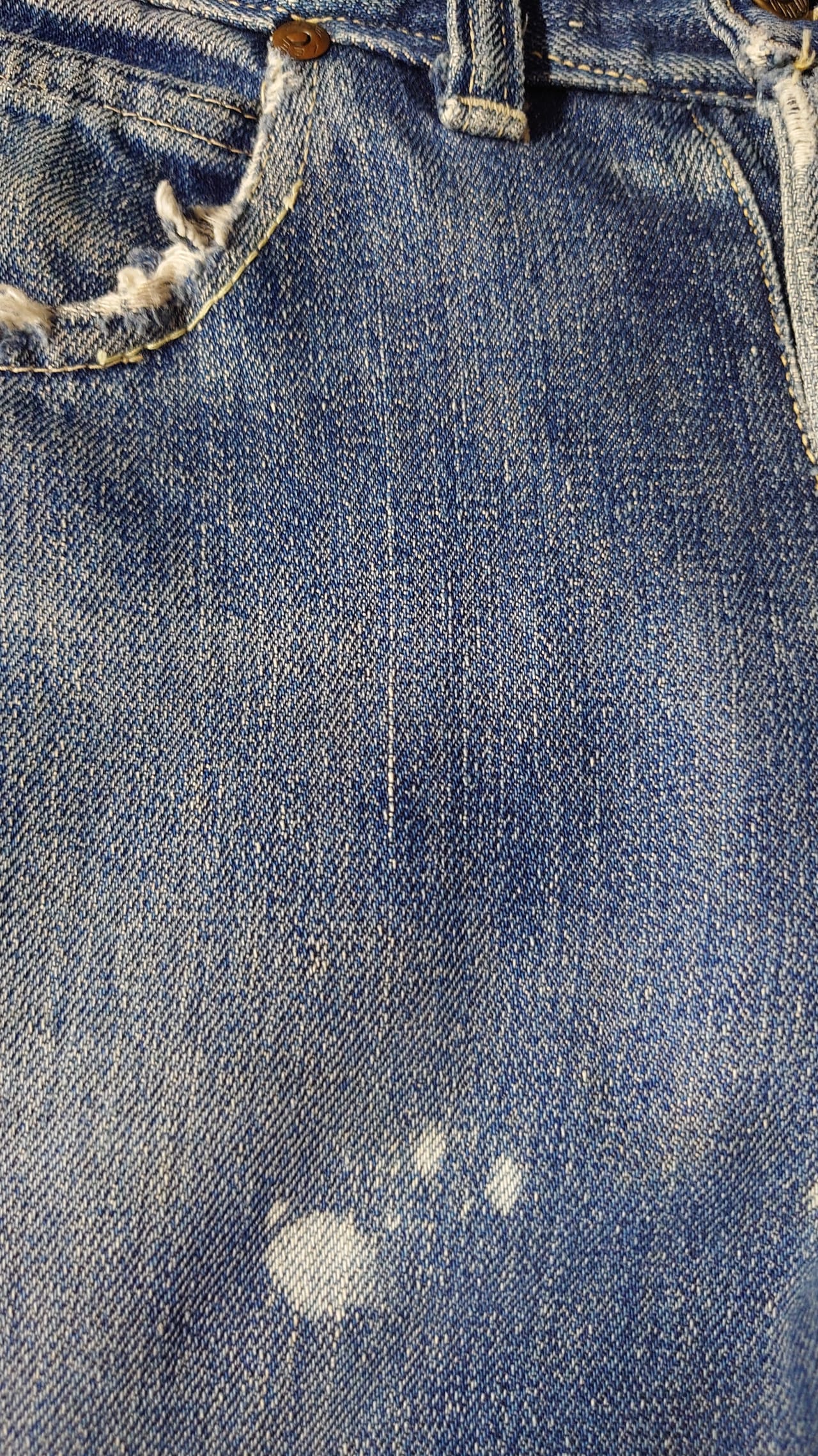 色落ちしたデニムに残ったペンキの飛び跡とポケット周りのアタリ