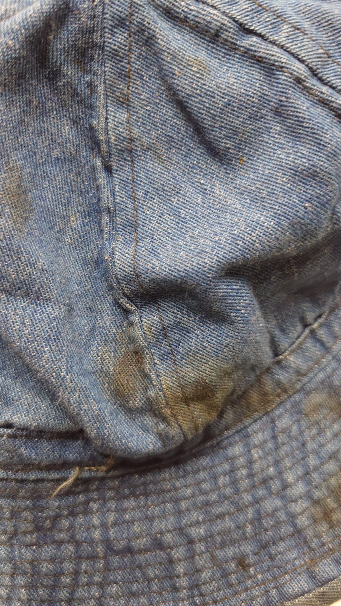 Close-up of the crotch of a vintage work pant heavily soaked with dark oil stains